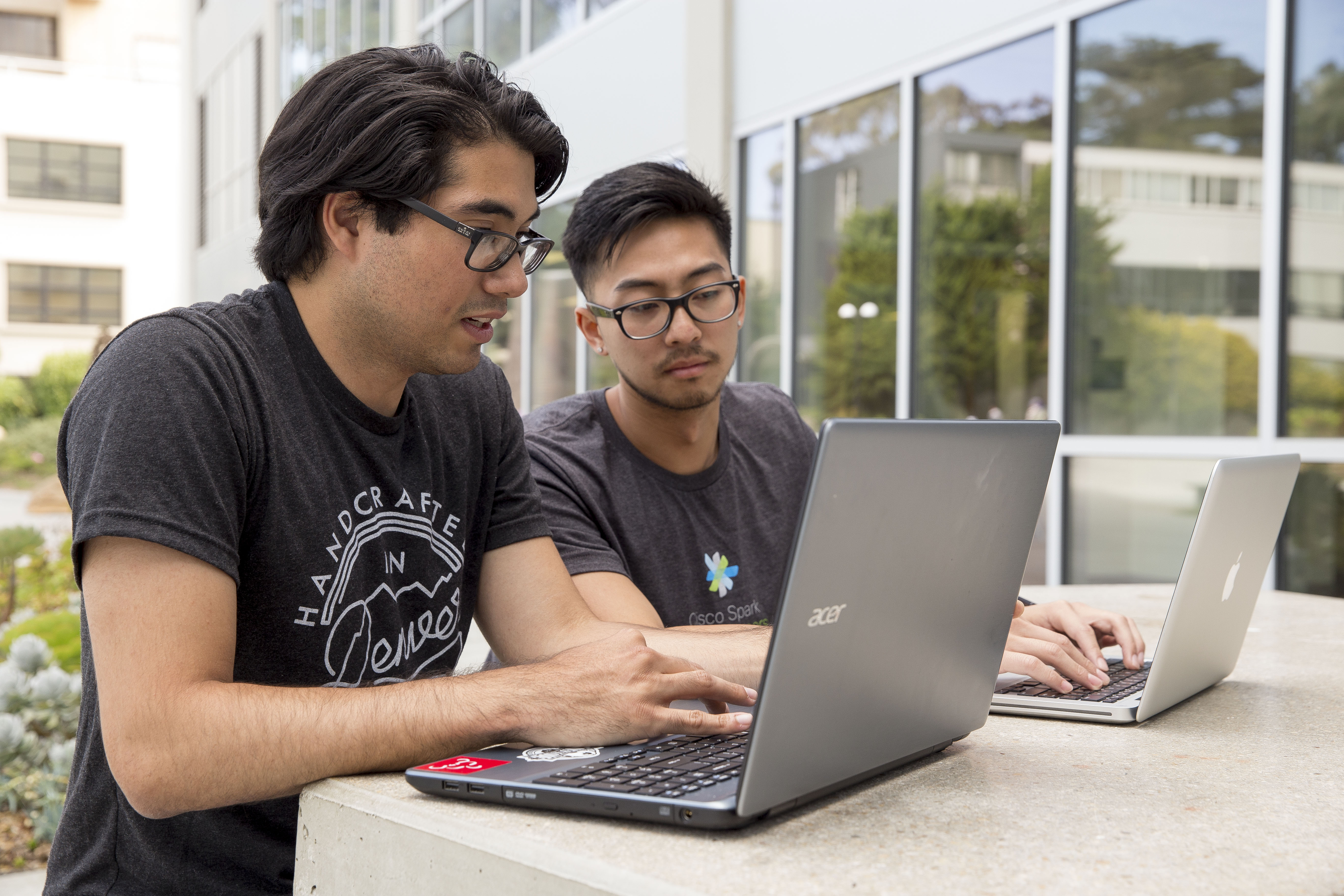 Two students looking at a laptop screen.